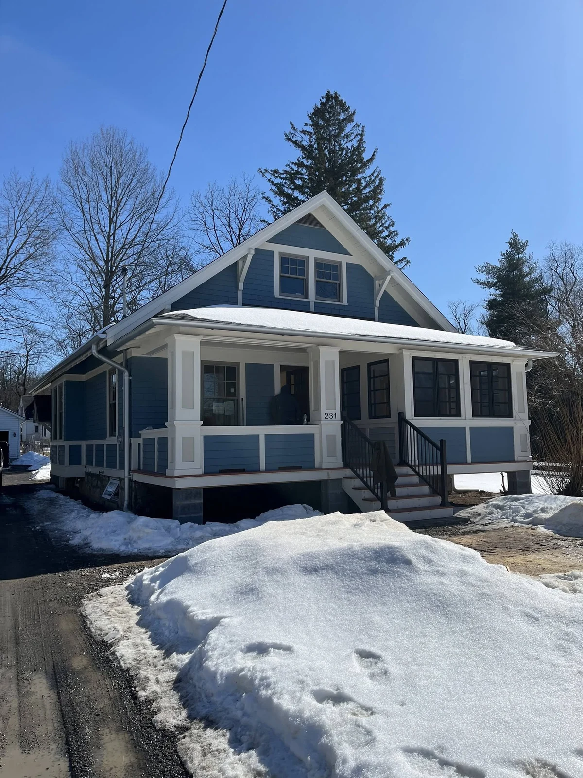 After: blue house with white porch trim and black railings