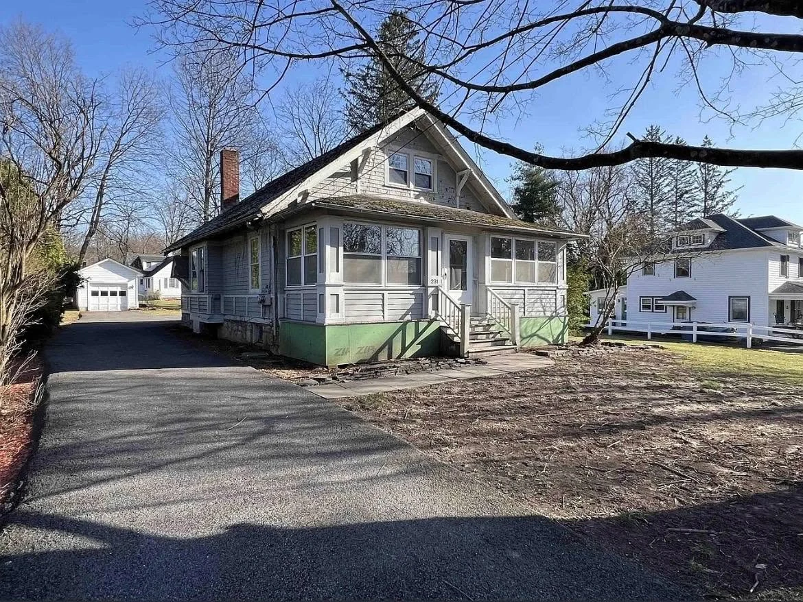 Before: gray house with green foundation and older porch